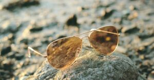 Close-up of authentic designer sunglasses lens showing clear engraved brand logo and model number
