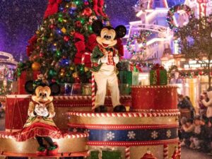 Mickey Mouse and Minnie Mouse in holiday costumes waving to guests during Mickey's Very Merry Christmas Party at Magic Kingdom