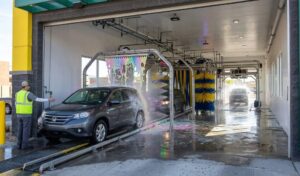 Vehicle entering the Quick Quack wash tunnel conveyor